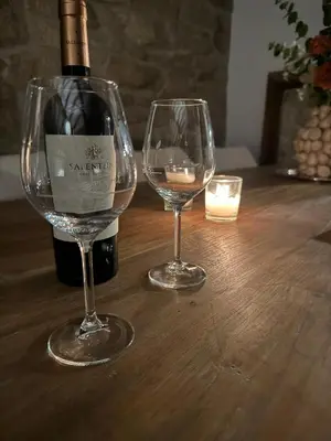 two wine glasses and a bottle of wine on a wooden table at Cima de Vila in Taboada
