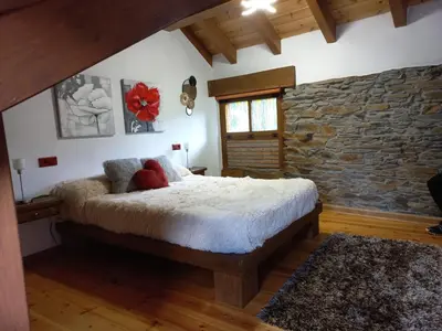 a bedroom with a bed and a stone wall at El Pajar de Triana in Brañuelas