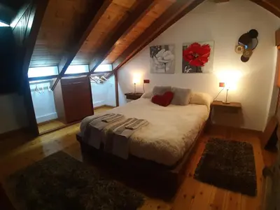 a bedroom with a large bed in a attic at El Pajar de Triana in Brañuelas