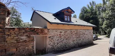 a brick building with a window and a stone wall at El Pajar de Triana in Brañuelas
