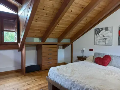 a bedroom with a large bed and a wooden ceiling at El Pajar de Triana in Brañuelas