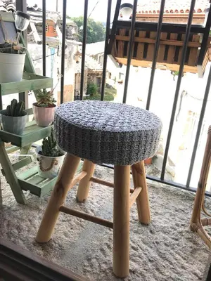 a knitted table sitting on top of a wooden stool at Casa Media Lúa in Allariz