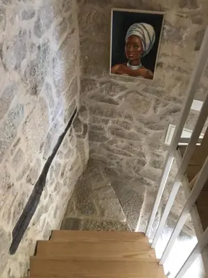 a stairway with a painting of a woman on the wall at Casa Media Lúa in Allariz