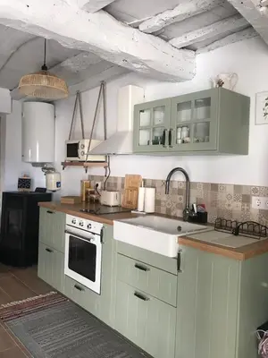 a kitchen with green cabinets and a sink at Casa Media Lúa in Allariz