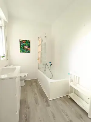 a white bathroom with a tub and a sink at Apartamento Maruja Mallo in Viveiro