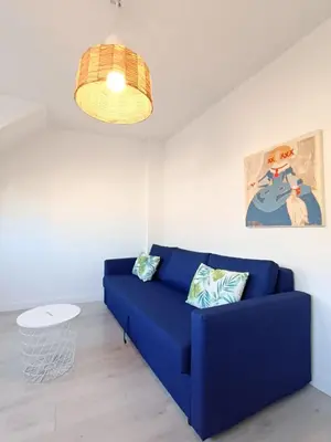 a blue couch in a living room with a lamp at Apartamento Maruja Mallo in Viveiro
