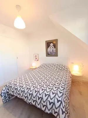 a bedroom with a bed with a black and white comforter at Apartamento Maruja Mallo in Viveiro