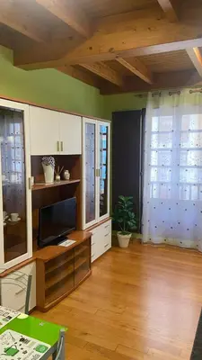 a living room with a tv on a wooden floor at Nido 33 in Ribadeo