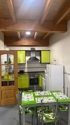 a kitchen with a table with chairs and a refrigerator at Nido 33 in Ribadeo