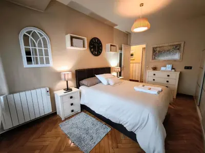 a bedroom with a large bed and a clock on the wall at piso céntrico y muy luminoso 1C in Santiago de Compostela