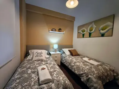 a small room with two beds with towels on them at piso céntrico y muy luminoso 1C in Santiago de Compostela