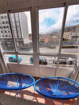 two blue chairs sitting in front of a window at piso céntrico y muy luminoso 1C in Santiago de Compostela