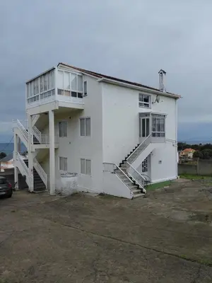 a white building with stairs on the side of it at Villa Laxes in Burela de Cabo