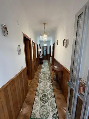 a hallway with a tile floor and a chandelier at Villa Laxes in Burela de Cabo