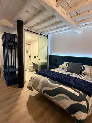a bedroom with a large bed and a bathroom at Adiva A Zapataría in Puentedeume
