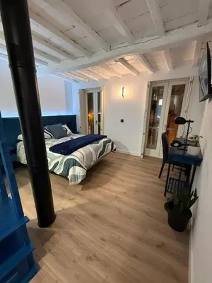 a bedroom with a bed and a desk in it at Adiva A Zapataría in Puentedeume