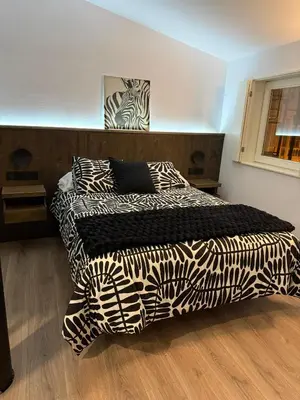 a bedroom with two beds with black and white sheets at Adiva A Zapataría in Puentedeume