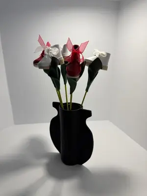 a black vase with a bunch of flowers in it at Adiva A Zapataría in Puentedeume