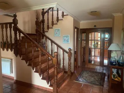 a staircase in a living room with a wooden stair case at Lar do Pero - Ribeira Sacra