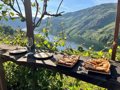 a table with two plates of food and a glass of wine at Lar do Pero - Ribeira Sacra
