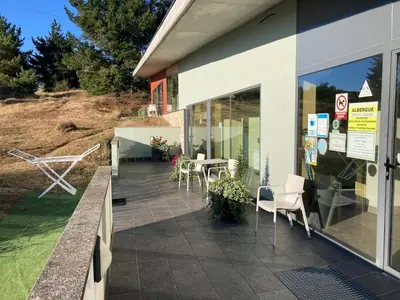 a patio with chairs and tables outside of a building at Albergue Casa Cruceiro de Ferreiros in Ferreiros
