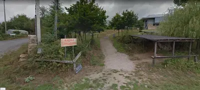 a sign on the side of a road next to a building at Albergue Casa Cruceiro de Ferreiros in Ferreiros