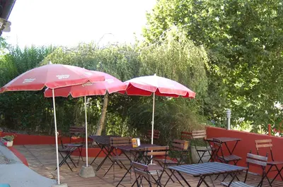 two tables and chairs with umbrellas on a patio at Casa Do Ferreiro - La Fragua in Las Herrerías