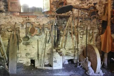 a wall with a bunch of utensils in a room at Casa Do Ferreiro - La Fragua in Las Herrerías