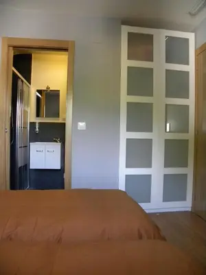 a bedroom with a bed and a kitchen in it at Casa Do Ferreiro - La Fragua in Las Herrerías