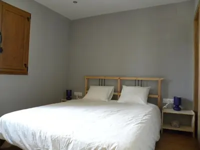 a bedroom with a large white bed with two pillows at Casa Do Ferreiro - La Fragua in Las Herrerías