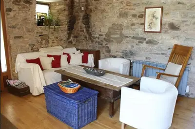 a living room with a couch and a table and chairs at Casa Do Ferreiro - La Fragua in Las Herrerías