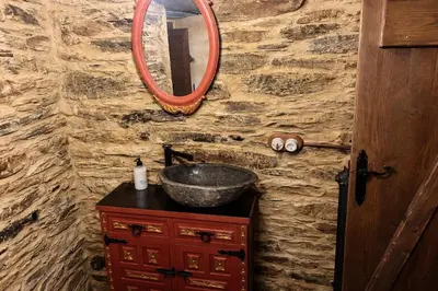 a bathroom with a sink and a mirror on a stone wall at Winahost Apartamento Neipin in Neipín
