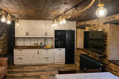 a kitchen with white cabinets and a black refrigerator at Winahost Apartamento Neipin in Neipín