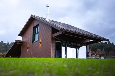 a house with a roof on top of a green field at Vencello Estelar Compostela in Santiago de Compostela