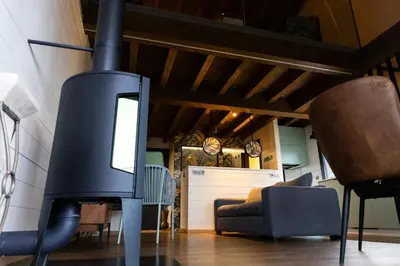 a fireplace in a living room with a couch and chairs at Vencello Estelar Compostela in Santiago de Compostela
