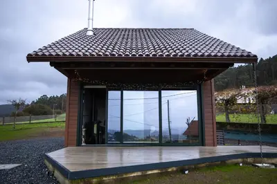 a small building with a large glass window at Vencello Estelar Compostela in Santiago de Compostela