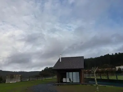 a small building with a roof on a field at Vencello Estelar Compostela in Santiago de Compostela