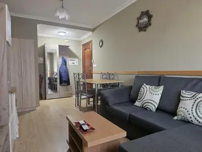 a living room with a blue couch and a table at Apartamentos Camino Inglés 3 in O Mesón Do Vento