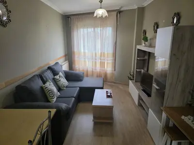 a living room with a blue couch and a table at Apartamentos Camino Inglés 3 in O Mesón Do Vento