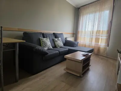 a living room with a blue couch and a coffee table at Apartamentos Camino Inglés 3 in O Mesón Do Vento