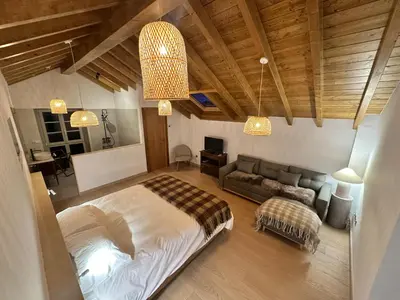 a bedroom with a large bed with two lights at Casa Rural A Costa - Villa Rustica Asturias - Boal
