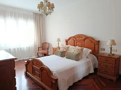 a bedroom with a large bed and a chandelier at Casa Josefa in Villalba