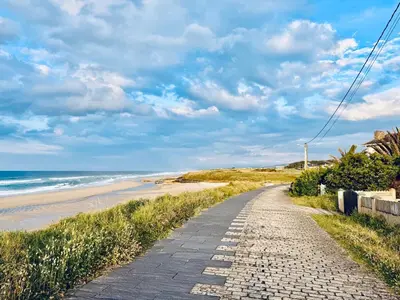 a walkway leading to the beach on a cloudy day at Casa de Mia Beachfront Home Playa de las Catedrales Ribadeo in Pena