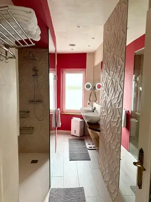a bathroom with red walls and a sink at Casa de Mia Beachfront Home Playa de las Catedrales Ribadeo in Pena