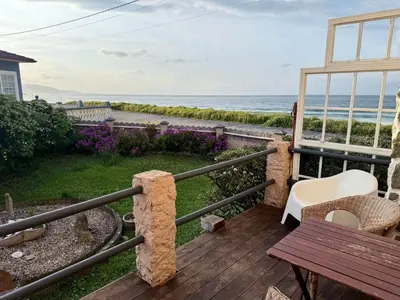 a deck with a bench and a view of the ocean at Casa de Mia Beachfront Home Playa de las Catedrales Ribadeo in Pena