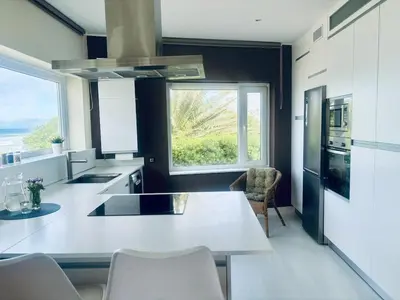 a kitchen with a white counter and a large window at Casa de Mia Beachfront Home Playa de las Catedrales Ribadeo in Pena
