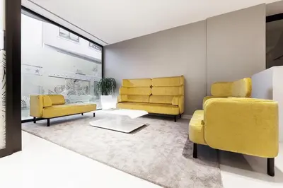 a living room with two yellow chairs and a table at Hotel Cardenal in Monforte de Lemos
