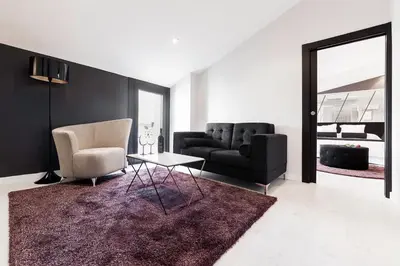 a living room with a couch and a chair and a table at Hotel Cardenal in Monforte de Lemos