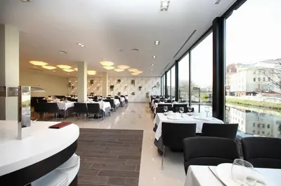 a restaurant with tables and chairs and large windows at Hotel Cardenal in Monforte de Lemos