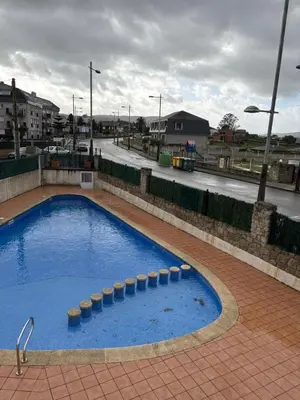 a large blue swimming pool on a brick floor at El rincón de la Mariña in San Cosme de Barreiros